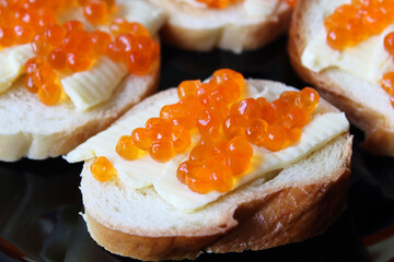 Sandwiches with butter and red caviar. Selective focus. Close-up. Background.