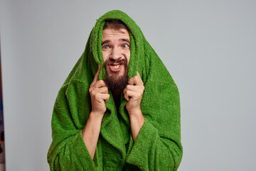 Bearded man in green robe cropped view gray background close-up