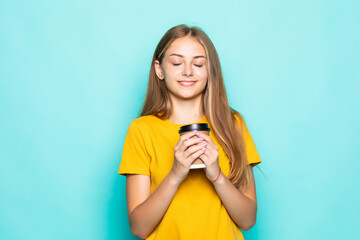 Happy woman smiling and drinking coffee isolated over turquoise background