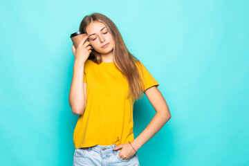 Happy woman smiling and drinking coffee isolated over turquoise background