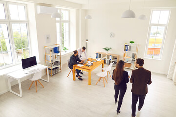 Top view of various business colleagues working in a modern office or coworking space.