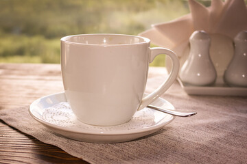 Cup of coffee with a saucer on the table in the cafe.