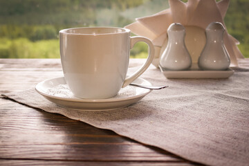 Cup of coffee with a saucer on the table in the cafe.