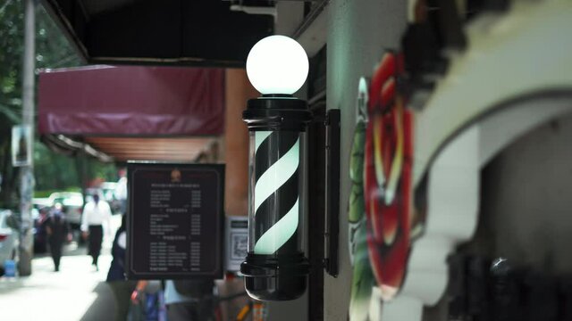 Traditional Black and White Barber Pole Light Outside a Barbershop