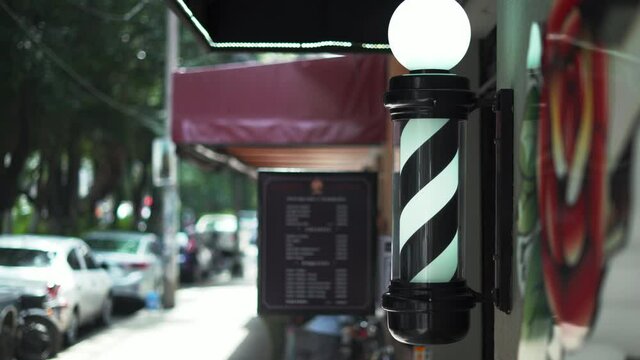 Traditional Black and White Barber Pole Light Outside a Barbershop