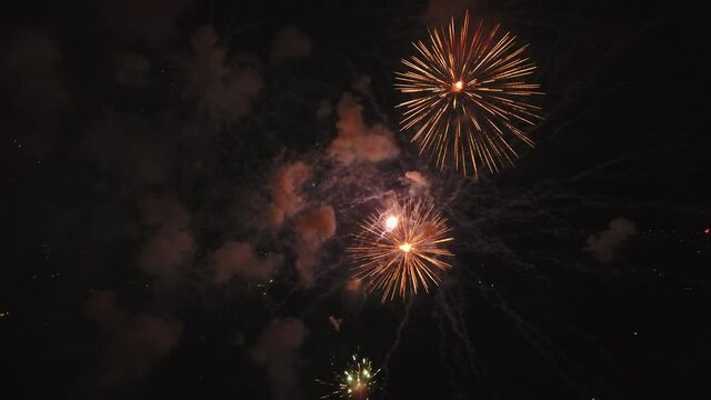 Colorful igniting fireworks in Utah at night, wide aerial
