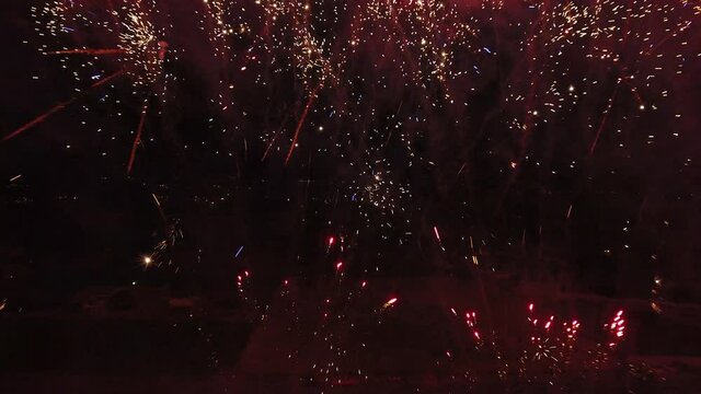 Red firework show over field in Utah, wide aerial