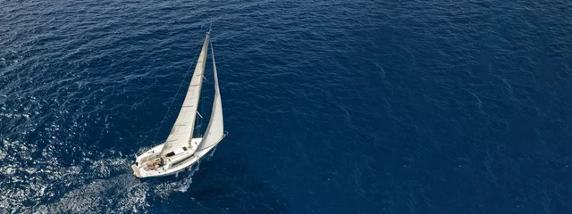 Fotobehang Zeilen Aerial drone ultra wide photo of sailboat cruising deep blue sea  © aerial-drone