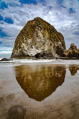 Haystack Rock, a sea stack on the Oregon coast reflected in the water