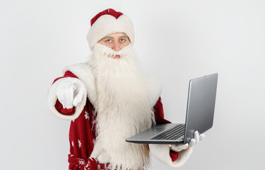 Santa Claus sits at his desk and works at the computer.