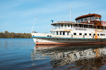Fragment of an old rusty ship on the river