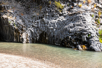 Basalt rocks and pristine water of Alcantara gorges in Sicily, Italy