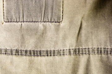 clothing items stonewashed cotton fabric texture with seams, clasps, buttons and rivets, macro