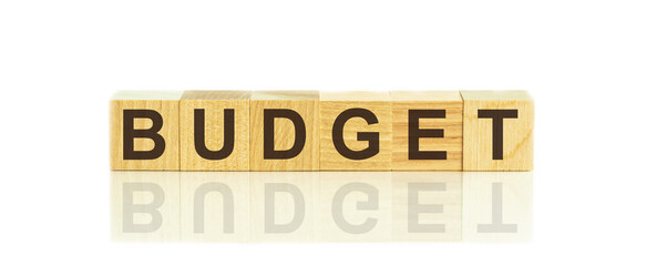 Wooden Blocks with the text: Budget. The text is written in black letters and is reflected in the mirror surface of the table.