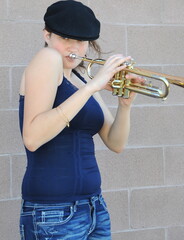 Female jazz trumpet player outdoors.