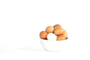 Eggs lay on white background. Food ingredient. Close-up view of raw chicken eggs in bowl.