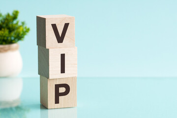 Word VIP made with wood building blocks on a light blue background
