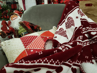 Sofa with cozy blanket, pillow and santa claus