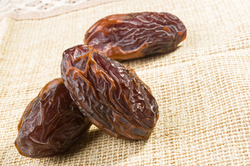 Big luxury dried date fruit on a linen napkin, kurma ramadan kareem concept, close up.