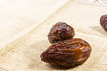 Big luxury dried date fruit on a linen napkin, kurma ramadan kareem concept, close up.