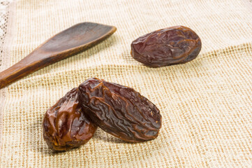 Big luxury dried date fruit on a linen napkin, kurma ramadan kareem concept, close up.