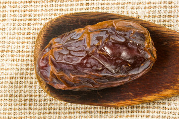 Big luxury dried date fruit on a linen napkin, kurma ramadan kareem concept, close up.