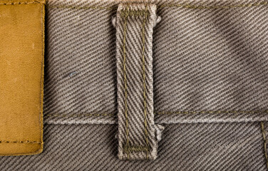 clothing items stonewashed cotton fabric texture with seams, clasps, buttons and rivets, macro