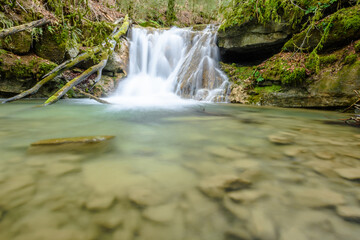 Beautiful little waterfall and colorful green pond. (Vallfogona de Ripolles, Torrent de la Masica, Catalonia, Spain)