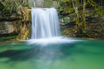 Beautiful little waterfall and colorful green pond. (Vallfogona de Ripolles, Torrent de la Masica, Catalonia, Spain)