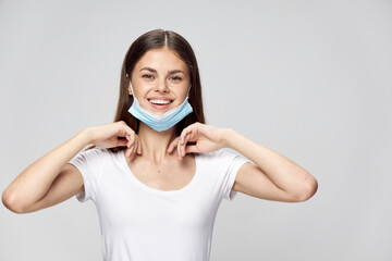 Woman in medical mask cheerful smile hands near face cropped view 