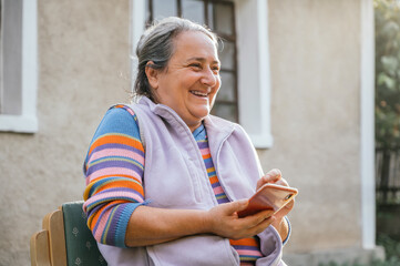 Elderly woman smiling and using her smart phone