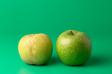 Two green apples on a green background