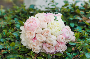 closeup wedding bouquet of roses lying on green leaves