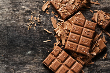 Broken chocolate bars on dark background