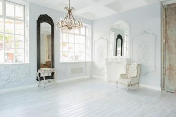 Luxury rich living room interior design with elegant classic furniture and wall decorations. Large light white room with big window