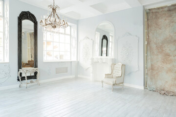 Luxury rich living room interior design with elegant classic furniture and wall decorations. Large light white room with big window