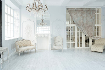 Luxury rich living room interior design with elegant classic furniture and wall decorations. Large light white room with big window