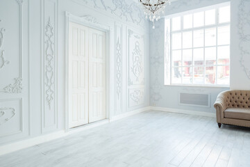 Luxury rich living room interior design with elegant classic furniture and wall decorations. Large light white room with big window