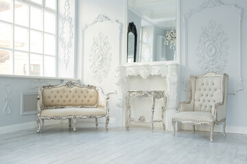 Obraz premium Luxury rich living room interior design with elegant classic furniture and wall decorations. Large light white room with big window