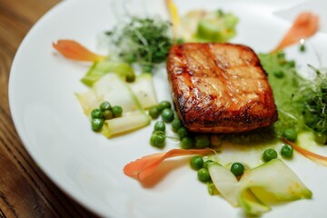 Grilled salmon fillet with salad on a white plate
