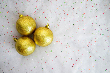 Three beautiful golden christmas balls on the white shiny background
