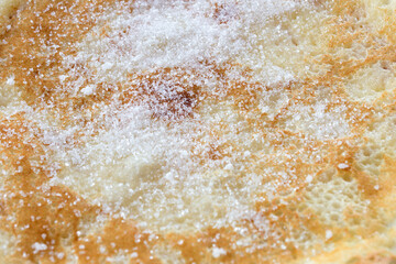 Close-up of sugar on traditional Spanish cake. Sweet pancake.