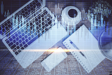 Financial market graph and top view computer on the desktop background. Double exposure. Investment concept.