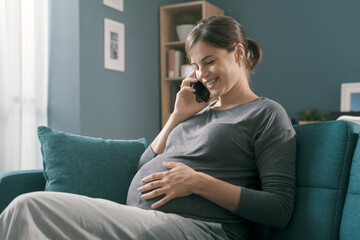 Happy pregnant woman talking on the phone