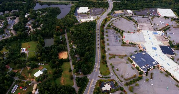 I fly over a shopping mall in High Point, NC on a Wednesday afternoon during the coronavirus COVID pandemic. Few vehicles can be seen in the parking lot showing how much of a retail impact.