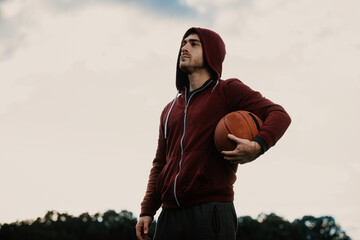 A young man with a face mask holding a basketball.