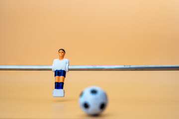 Table football player on orange background