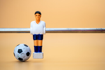 Table football player on orange background