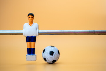 Table football player on orange background