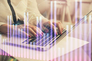 Multi exposure of woman hands typing on computer and financial graph hologram drawing. Stock market analysis concept.